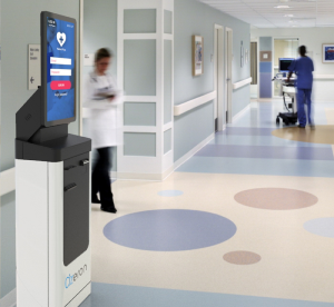 Patients and visitors in the hospital hallway are given directions by a digital kiosk in the hallway
